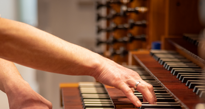 Unsere Foto zeigt zwei Hände auf der Tastatur einer Orgel.