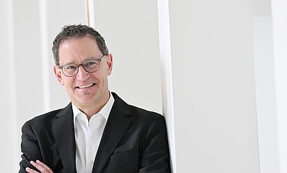 Das Foto zeigt den stellvertretenden Stadtdekan Michael Heil an einer Säule lehnend. 